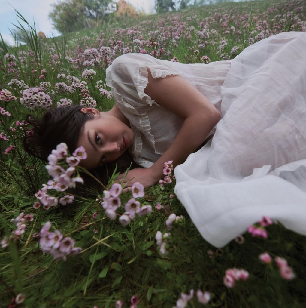Chad Moore, woman lying in a field of pink and white flowers
